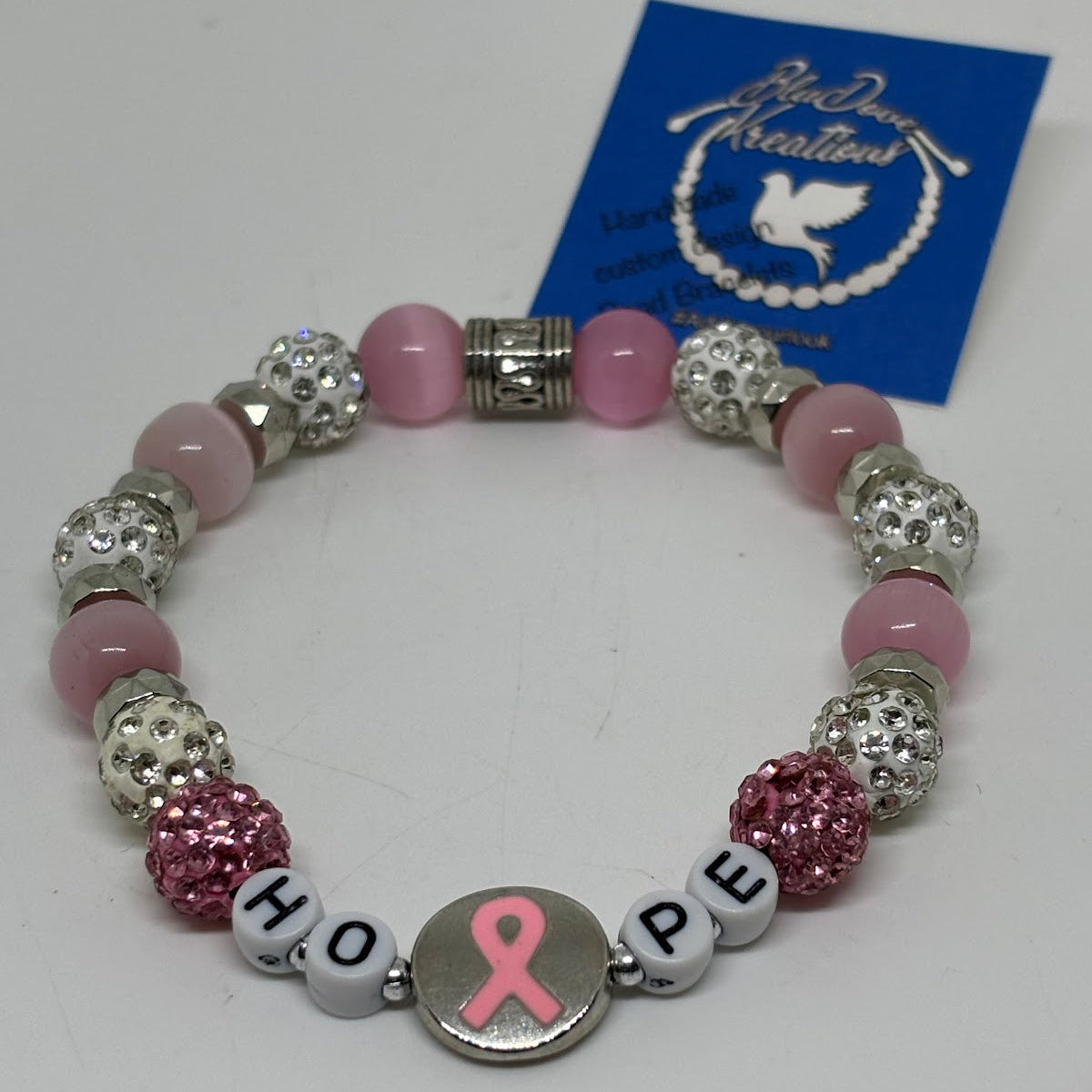 Bracelet with pink and silver beads and a 'Hope' charm on a white background