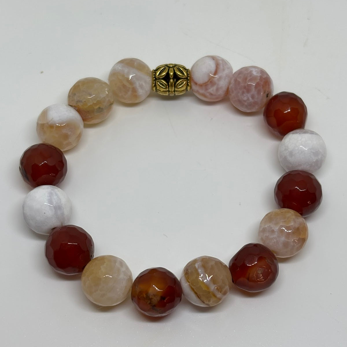 Beaded bracelet with multicolored beads and a gold clasp on a white background