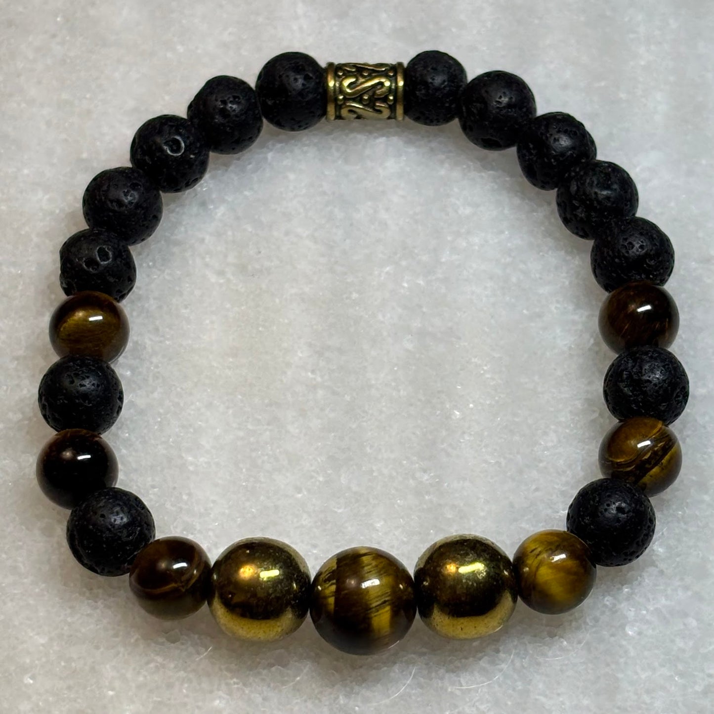 Beaded bracelet with black and brown beads on a textured white background