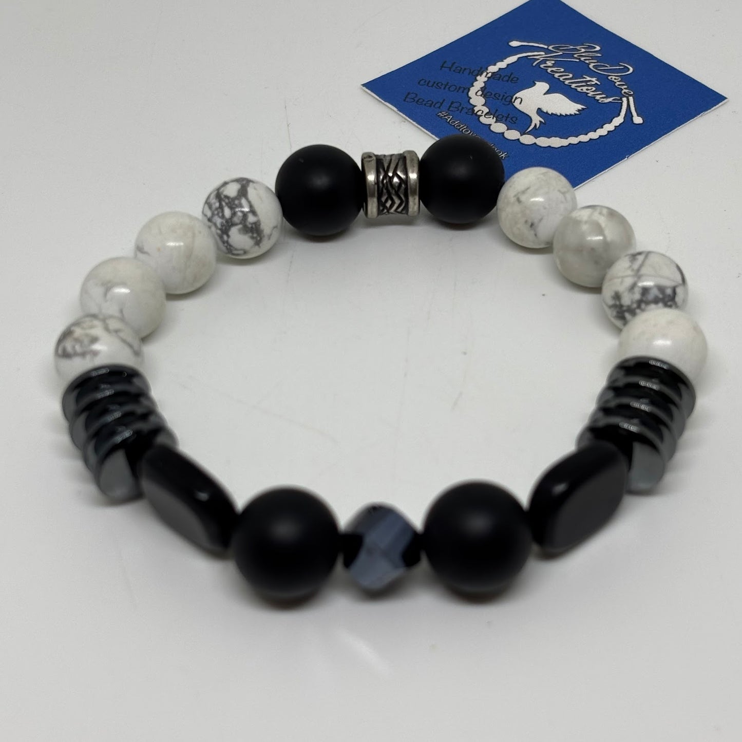 Black and white beaded bracelet on a white background with a brand card.