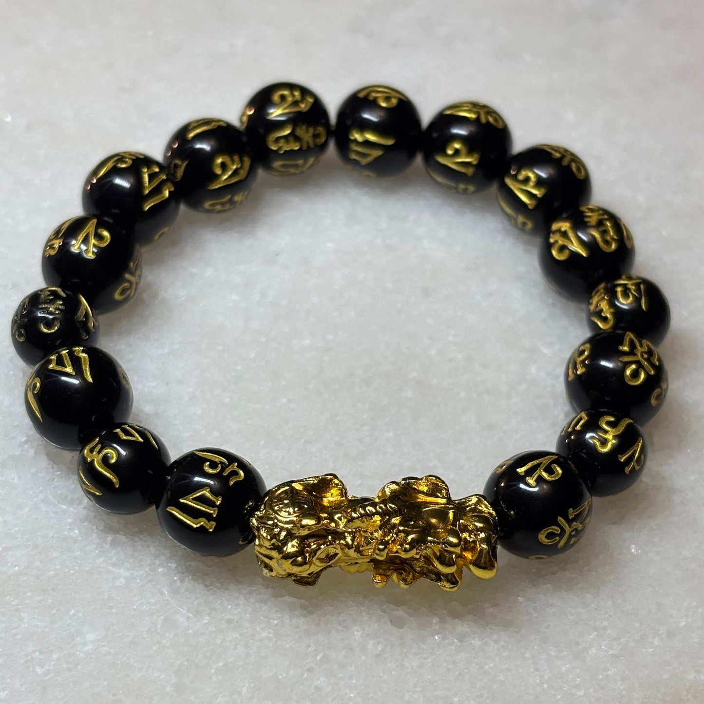 Black beaded bracelet with gold accents on a white background